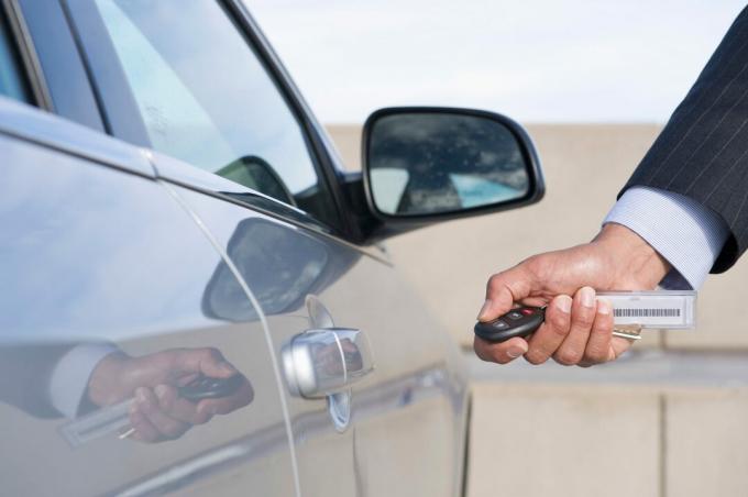 Шпански бизнисмен који користи електронски кључ за отварање врата аутомобила