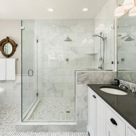 Peamine vannituba uues luksuslikus kodus: vann ja dušš koos plaaditud ja klaasist duširuumidega