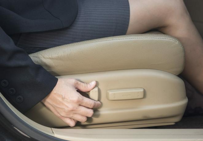 Pengusaha wanita menyesuaikan kursi listrik, kursi di dalam mobil