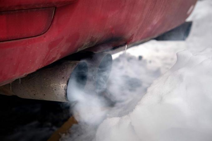 غازات العادم للسيارة دخان كثيف أبيض من المدخنة في الشتاء ضد الثلج الأبيض ، بيئة التلوث