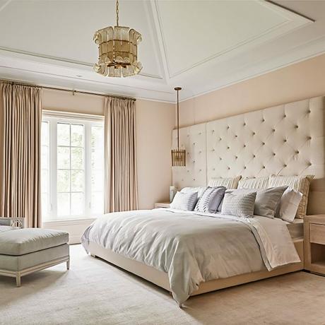Dormitorio con paredes ruborizadas y muebles color crema.