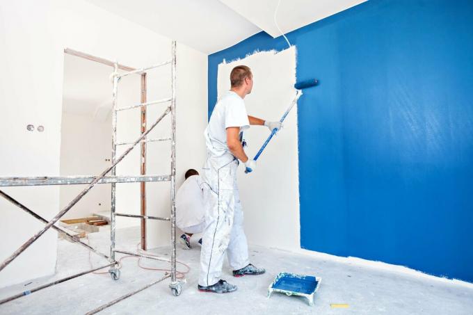 Бояджии боядисват стена в синьо
