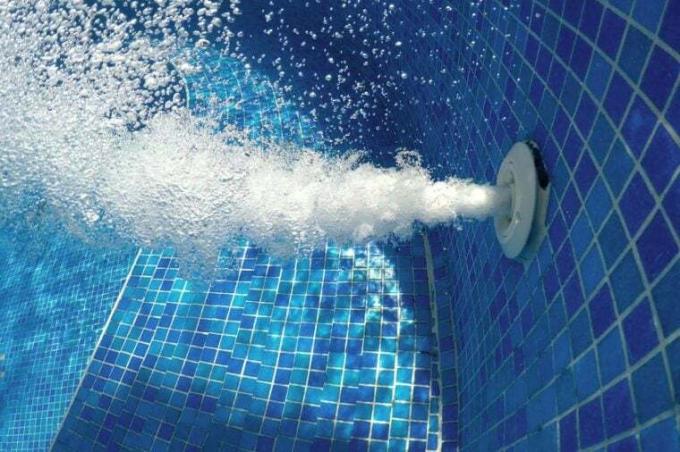Burbujas de aire del chorro de jacuzzi en agua azul burbujeante en una piscina de spa termal, fondo abstracto