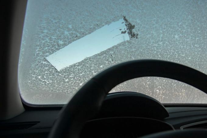 Παγωμένο πρωί και αυτοκίνητο με παράθυρο με πάγο. αφαιρώντας το χιόνι από το παράθυρο του αυτοκινήτου