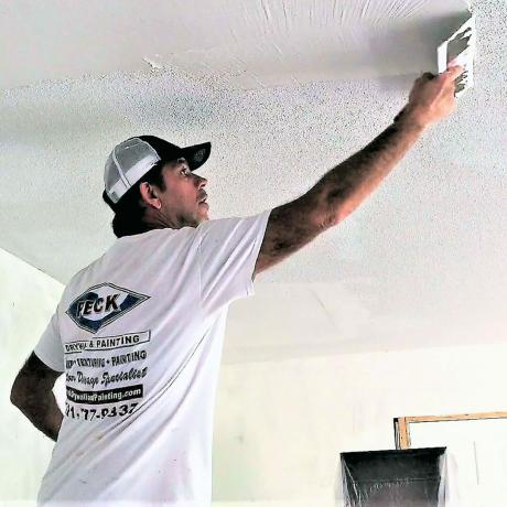 Uomo che applica un rivestimento di rasatura a un soffitto | Suggerimenti per i professionisti della costruzione