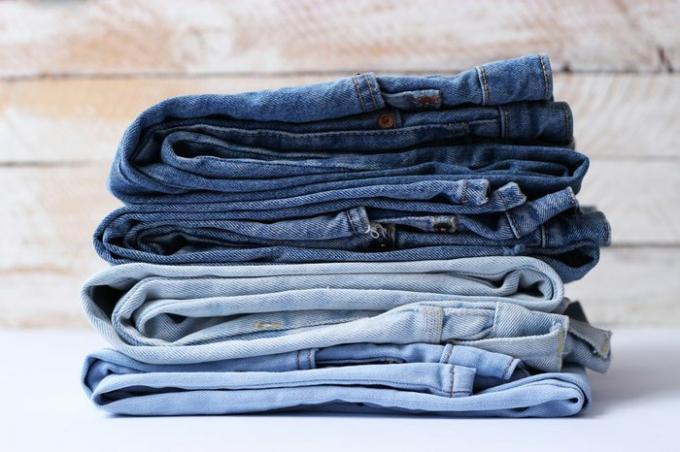 jeans dengan warna berbeda ditumpuk dalam tumpukan yang ideal. jeans di toko. penjualan.