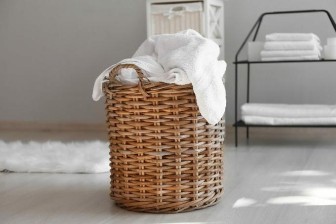 Koš na prádlo se špinavými ručníky na podlaze