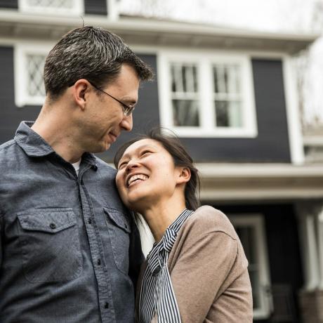 kjøpe et hus Par som står foran hjemmet