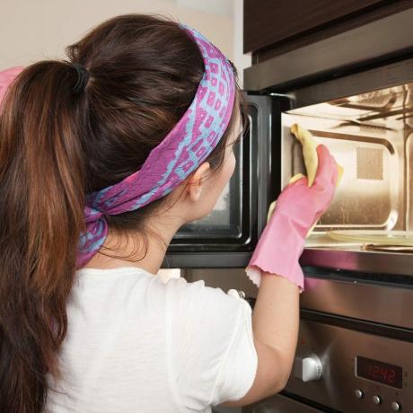ילדה מנקה תנור במטבח