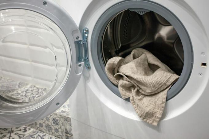 Handdoek die uit een wasmachine hangt