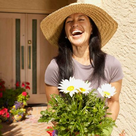 Donna che pianta fiori per aumentare l'attrattiva del marciapiede