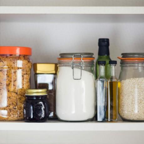 despensa de cocina equipada con alimentos: frascos y recipientes de cereales, mermelada, café, azúcar, harina, aceite, vinagre, arroz