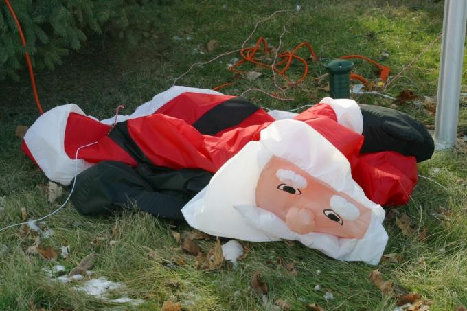 Papá Noel desinflado hincha la decoración del césped
