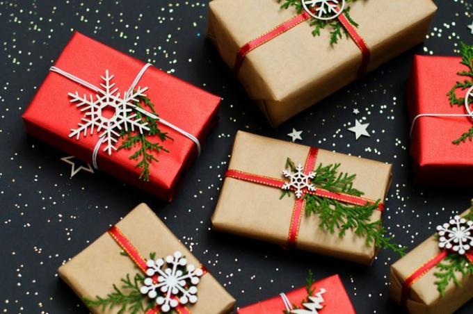 Regalo de Navidad. Cajas de regalo rojas hechas a mano de Navidad y papel artesanal en la vista superior de fondo oscuro. Feliz navidad tarjeta de felicitación. Feliz Año Nuevo. Endecha plana.