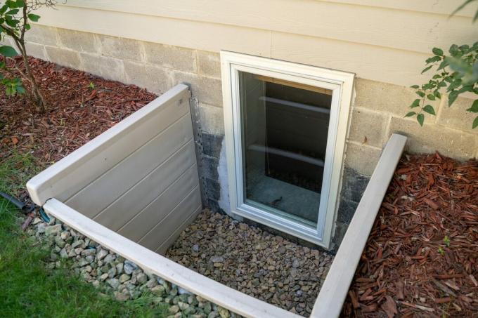 Exteriör vy av ett utträdesfönster i ett sovrum i källaren. Dessa fönster krävs som en del av USA: s brandkod för källarrum