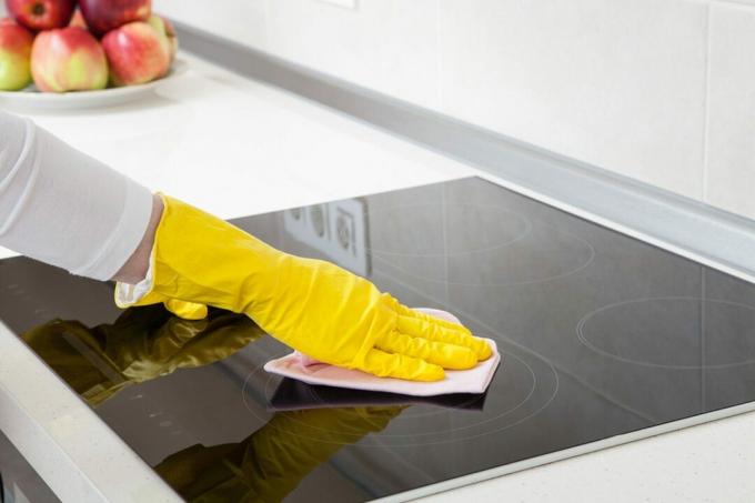 kvinde, der viser, hvordan man rengør et glas komfur