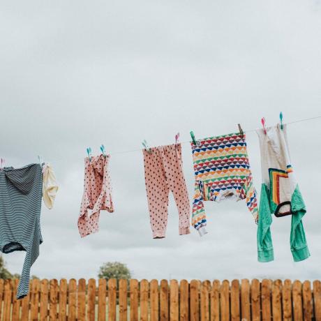 skalbiniai, pakabinti džiūti ant drabužių linijos kieme