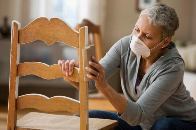 Жена мешовите расе поправља столицу у кући
