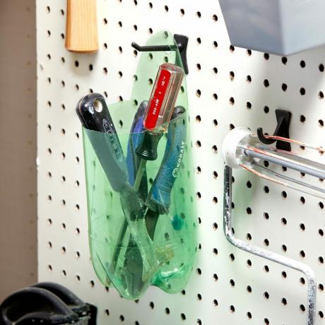 botella reciclada cortada para sujetar herramientas en un taller
