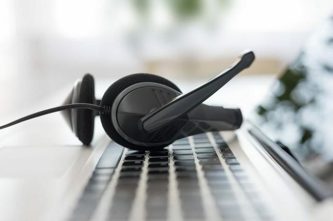 Communicatieondersteuning, callcenter en helpdesk voor klantenservice. VOIP-headset op het toetsenbord van de laptopcomputer.