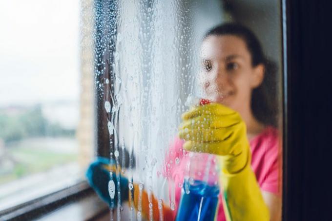 窓を洗う若い女性