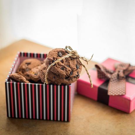 Šokoladiniai sausainiai ir dovanų dėžutė ant medinio stalo
