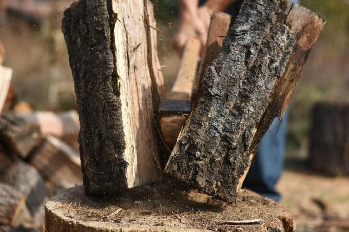 Мъж цепи дърва за огрев за зимата 