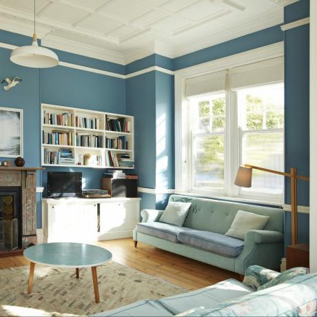 sala de estar con moldura de ventana interior alineada con rieles para cuadros y sillas