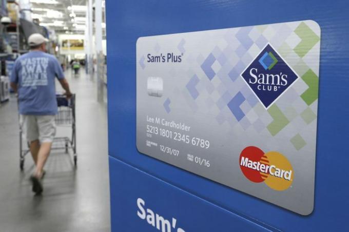 Un cliente pasa junto a un cartel que promociona tarjetas de crédito Sam's Club MasterCard en una tienda Sam's Club store en Bentonville, Arkansas