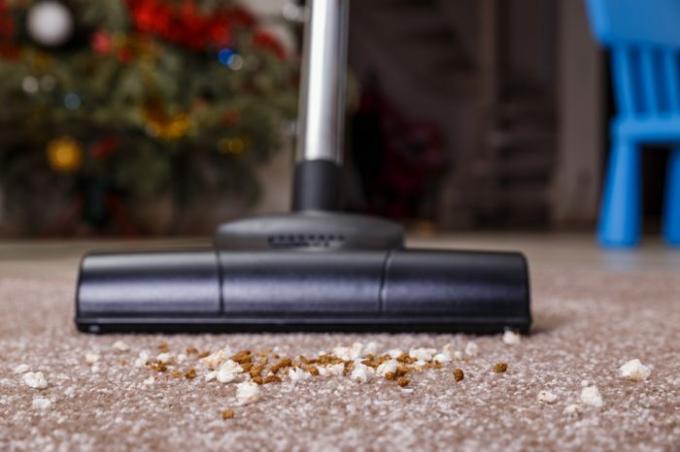Aspirar alfombra con aspiradora. Suciedad en la alfombra. Servicio de tareas domésticas. Cerca de la cabeza de un dispositivo de limpieza de barredora.