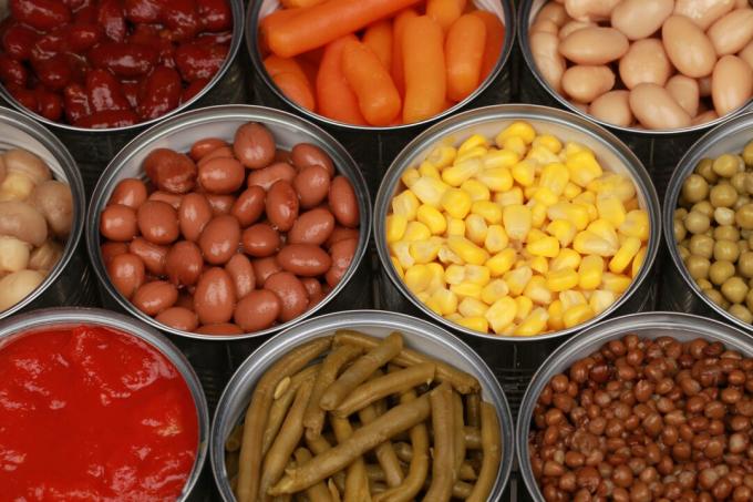 Diferentes tipos de verduras como maíz, guisantes y tomates en latas.