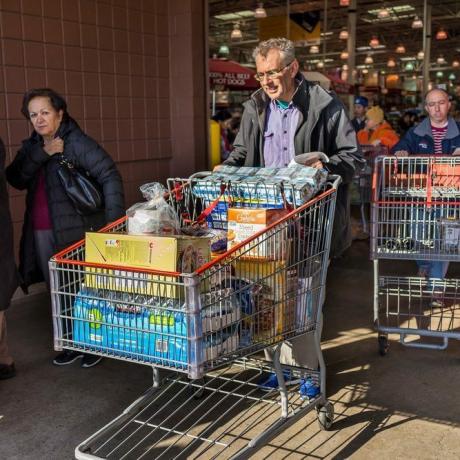 Fairfax, USA - 3. december 2016: Folk med indkøbsvogne fyldt med dagligvarer, der går ud af Costco -butikken i Virginia