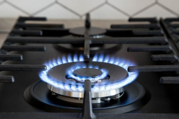 Plinski plamenik na crnoj modernoj kuhinjskoj peći. kuhinjski plinski štednjak s gorućom vatrom propan plin