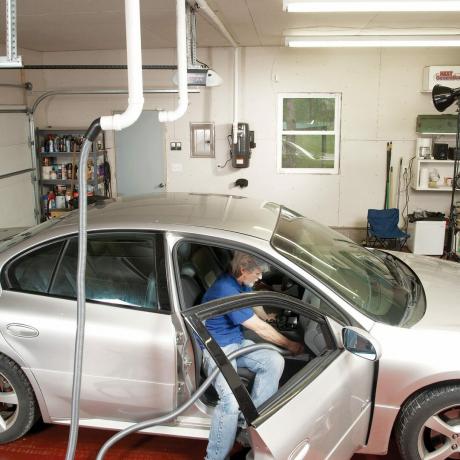 moški v garaži posesa notranjost svojega avtomobila
