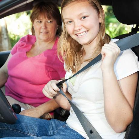 Genç-kız-annesinin-yanındaki-arabada-emniyet kemeri-bağlar