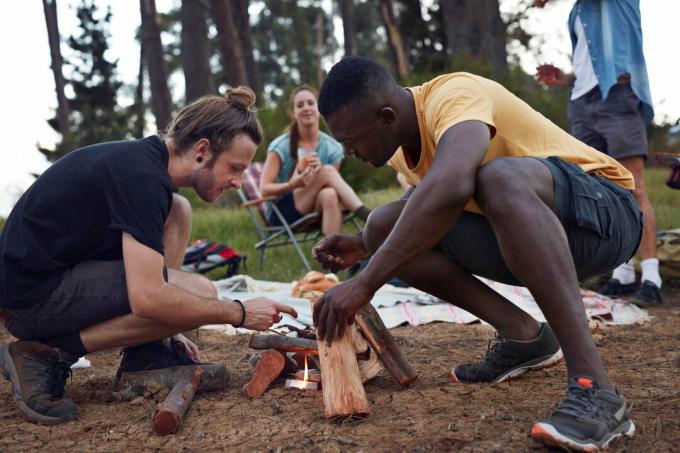 Venner starter et bål, mens de camperer på en campingplads