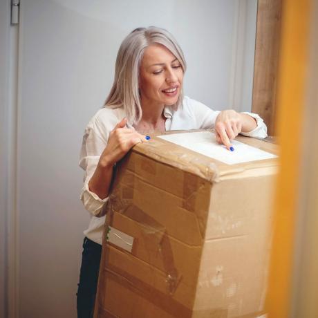 Kvinne mottar pakke fra leveringstjeneste for byggevarer