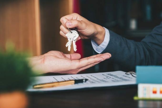 El agente entrega las llaves de la casa en una oficina por un acuerdo