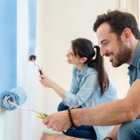 Junges Paar streicht Wände in ihrem neuen Haus, do it yourself-Konzept
