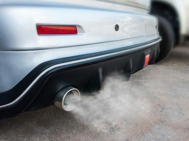 Издувна цев аутомобила јако излази из дима, концепт загађења ваздуха.