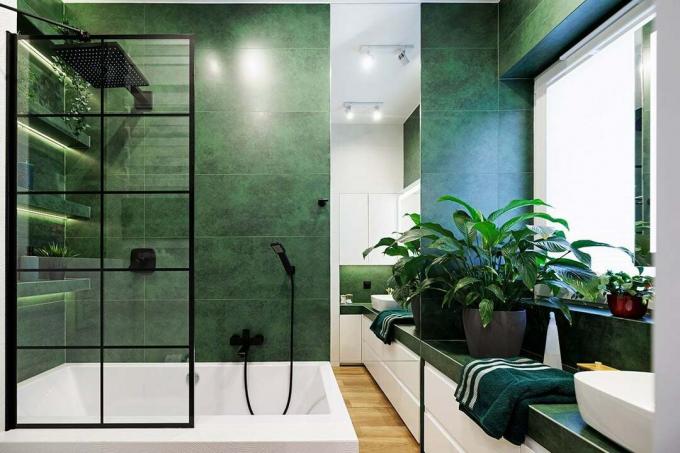 Groene luxe badkamer, zwarte regendouchekop en zwarte glazen paneelramen