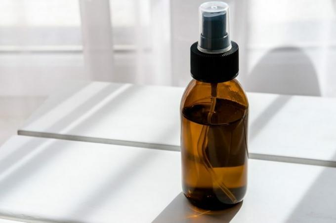 Braune Glassprühflasche mit Bio-Kosmetik auf weißem Tisch. Direktes Licht. Beauty-Blogging-Minimalismus-Konzept
