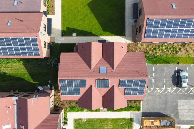 Luftfoto over en moderne boligutvikling med solcellepaneler installert på hustakene for bærekraftig elektrisitet