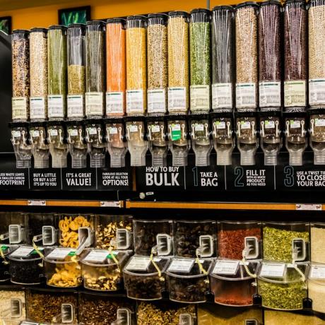 Una gran selección de alimentos secos a granel en dispensadores inteligentes y una balanza en una tienda de comestibles de lujo
