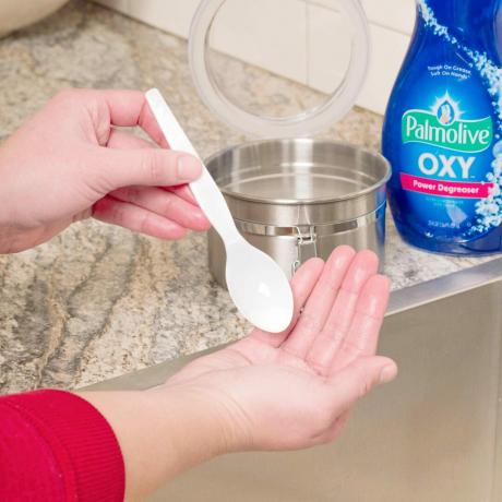 κοντινό πλάνο των χεριών χρησιμοποιώντας ένα κουτάλι για να εφαρμόσετε χειροποίητο σαπούνι