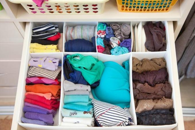 Дамско облекло в чекмеджетата на гардероба. Бельо, тениски и чорапи в килера. Вертикално съхранение.