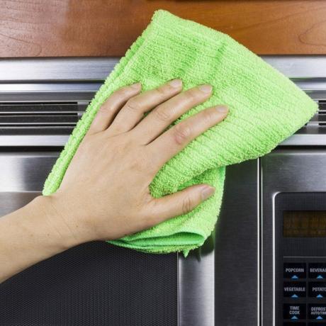Tangan dengan lap microfiber membersihkan ventilasi oven microwave; ID Shutterstock 121364071; Pekerjaan (TFH, TOH, RD, BNB, CWM, CM): Taste of Home