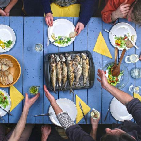 تناول العشاء الأسماك والمأكولات البحرية وجبة الأسرة الطرف