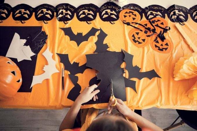 Hacer decoraciones de Halloween cortando murciélagos y calabazas con cartulina de colores