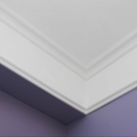 내부의 크라운 몰딩 코너 뷰; 보라색 벽, 흰색 크라운 몰딩이 있는 흰색 천장